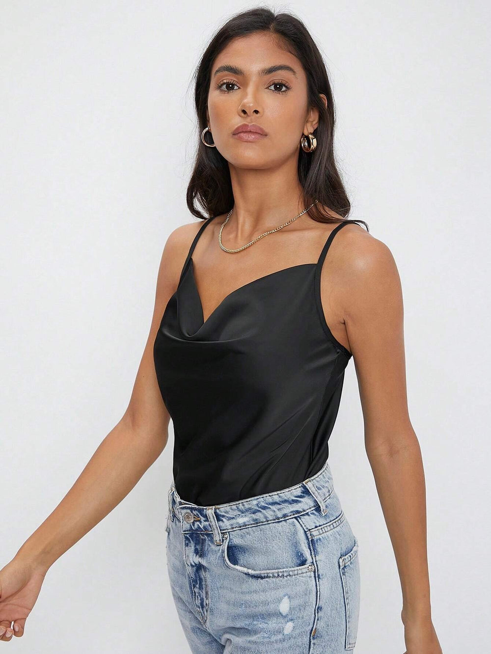 Vista frontal de la blusa negra de tirantes con diseño drapeado.