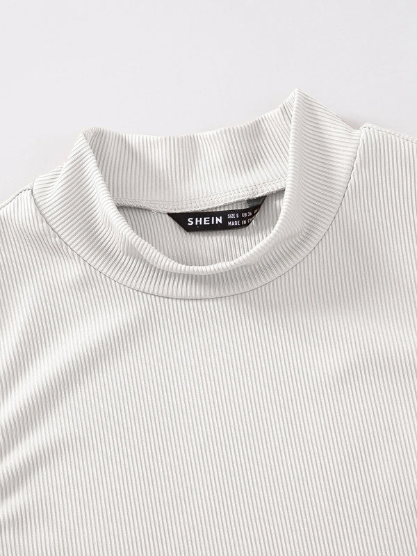 Detalle del cuello alzado y las costuras del top crop blanco canalé