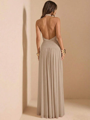 Primer plano del torso de un vestido beige con cuello halter y detalles fruncidos en el busto y la cintura.