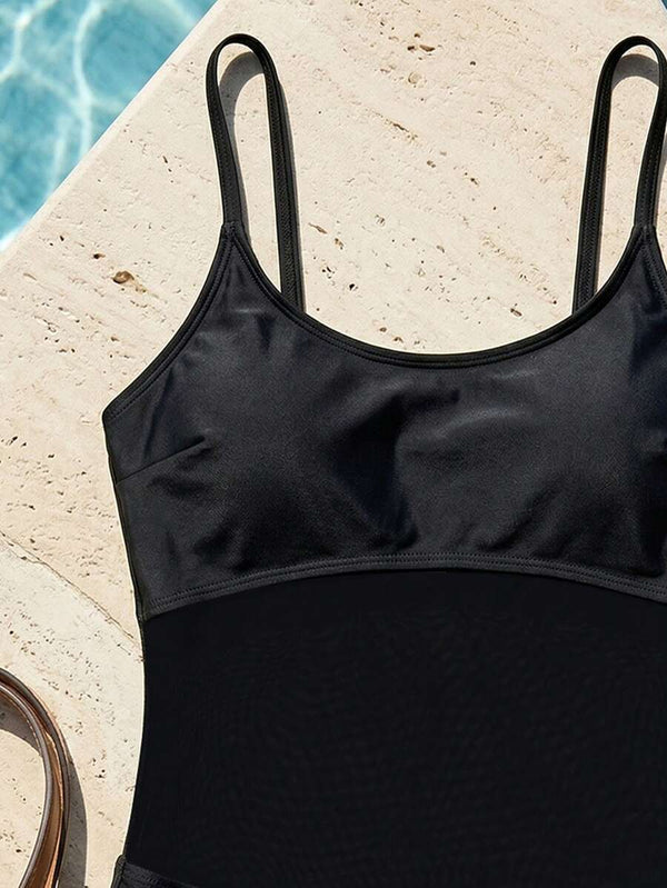 Primer plano del torso con malla transparente de enterizo negro