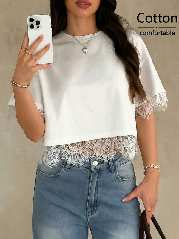 Primer plano del borde de encaje floral en el bajo de un top crop blanco sobre unos jeans.