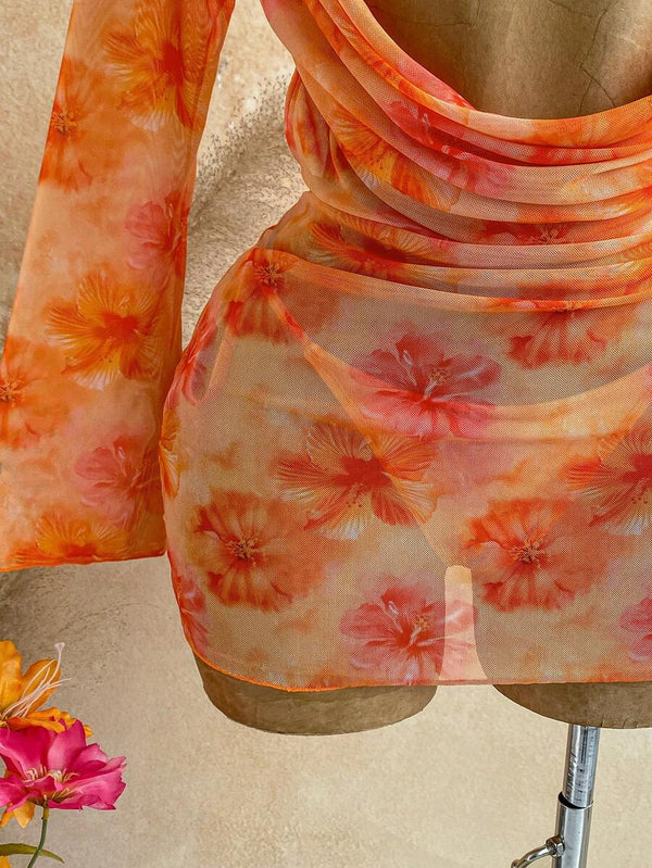 Detalle inferior del vestido de playa transparente sobre el bikini a juego y una bolsa de paja.