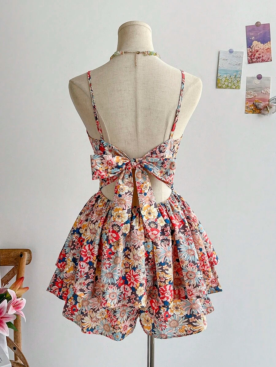 Vista frontal de un vestido corto floral bohemio con tirantes finos y falda de capas en un maniquí.