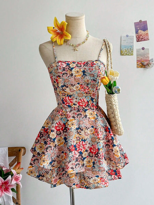 Vista frontal de un vestido corto floral bohemio con tirantes finos y falda de capas en un maniquí.