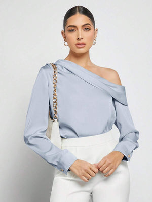 Primer plano de la manga larga y el puño de la blusa elegante celeste.