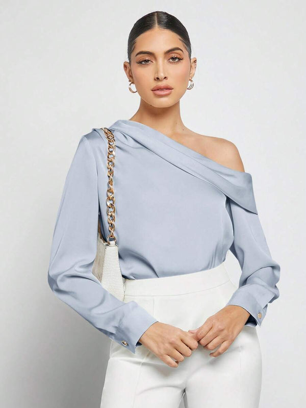 Primer plano de la manga larga y el puño de la blusa elegante celeste.