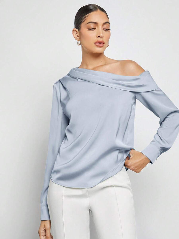 Cómo combinar la blusa celeste asimétrica con un pantalón blanco de talle alto.
