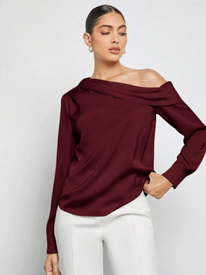 Detalle del ajuste de una blusa elegante color vino y su combinación con un pantalón de talle alto blanco.