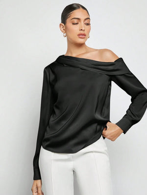 Vista frontal de top negro elegante con cuello asimétrico.