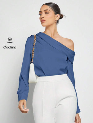 Vista frontal de una mujer usando una blusa azul asimétrica de un solo hombro con pantalones blancos.