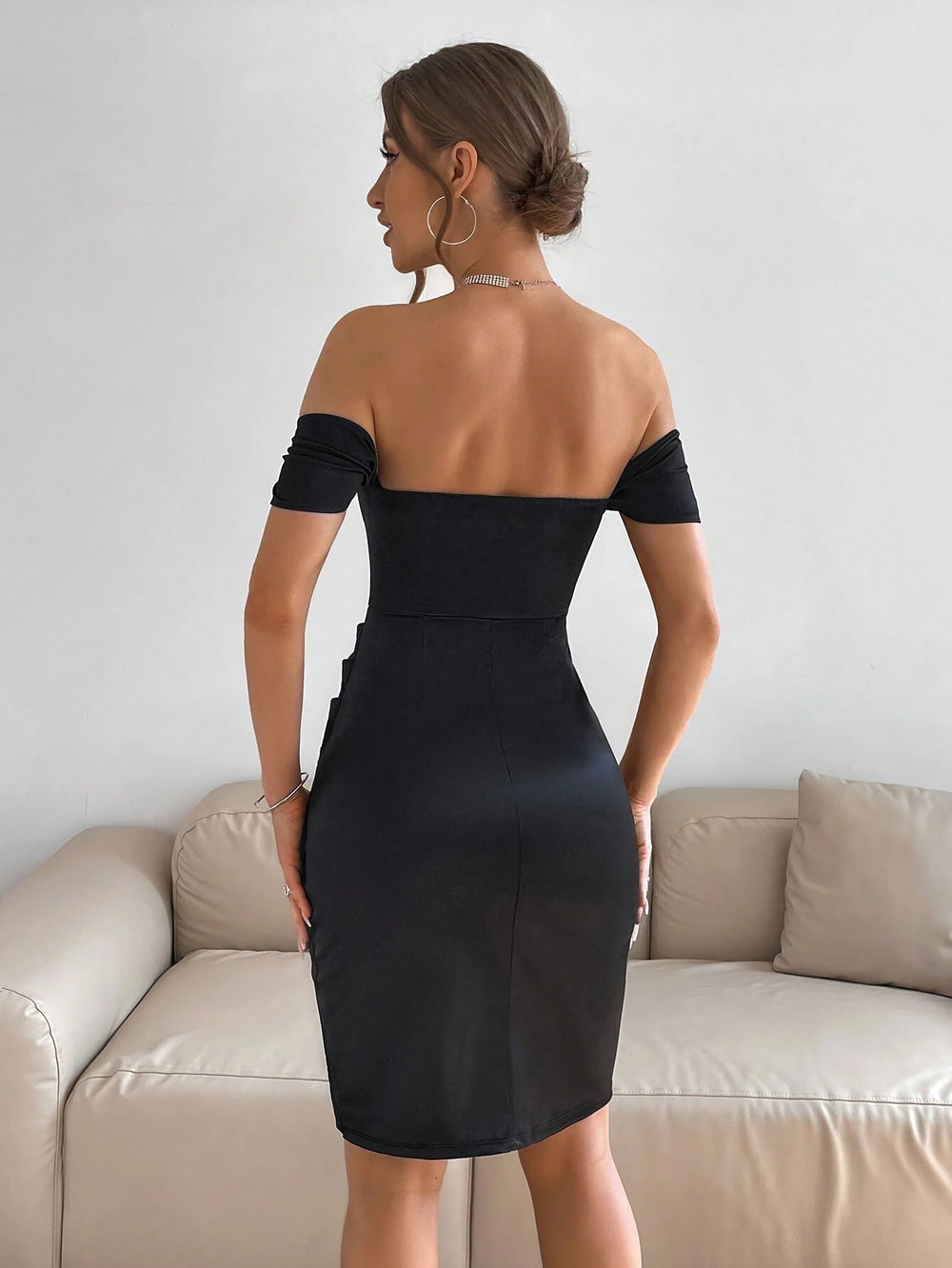 Vestido negro elegante ajustado de satén con hombros descubiertos vista frontal.
