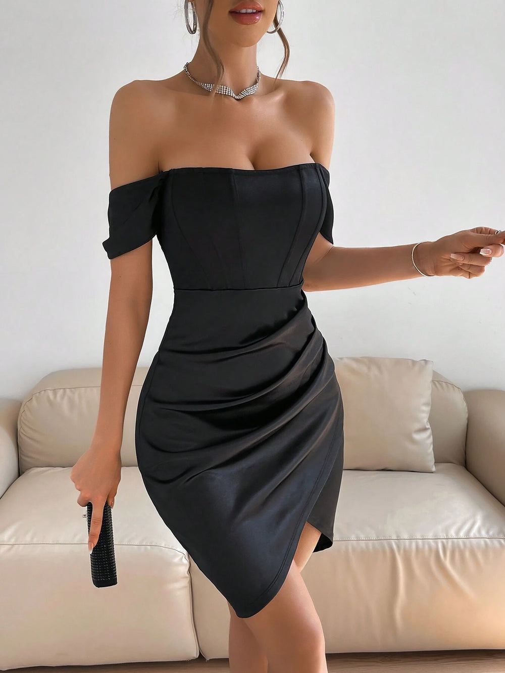 Vestido negro elegante ajustado de satén con hombros descubiertos vista frontal.