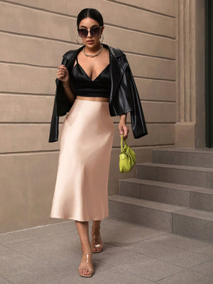 Falda albaricoque combinada con top negro y chaqueta.