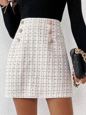 Detalle de la botonadura doble en la falda elegante con estampado a cuadros.