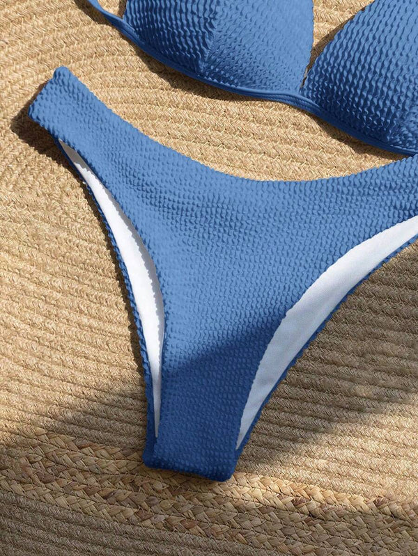 Braga de bikini azul de corte alto y tejido texturizado, mostrando su diseño moderno.