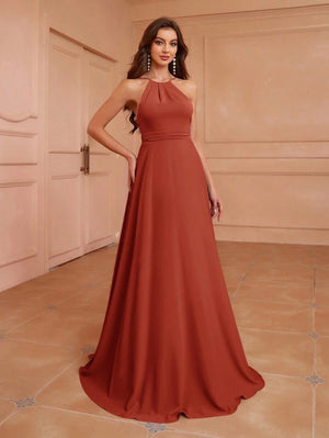 Primer plano de la espalda descubierta y los tirantes finos de un vestido elegante color terracota.
