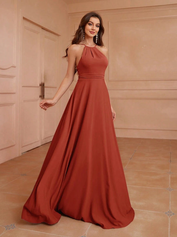 Mujer de espaldas mostrando el diseño completo de un vestido largo terracota ideal para eventos formales.