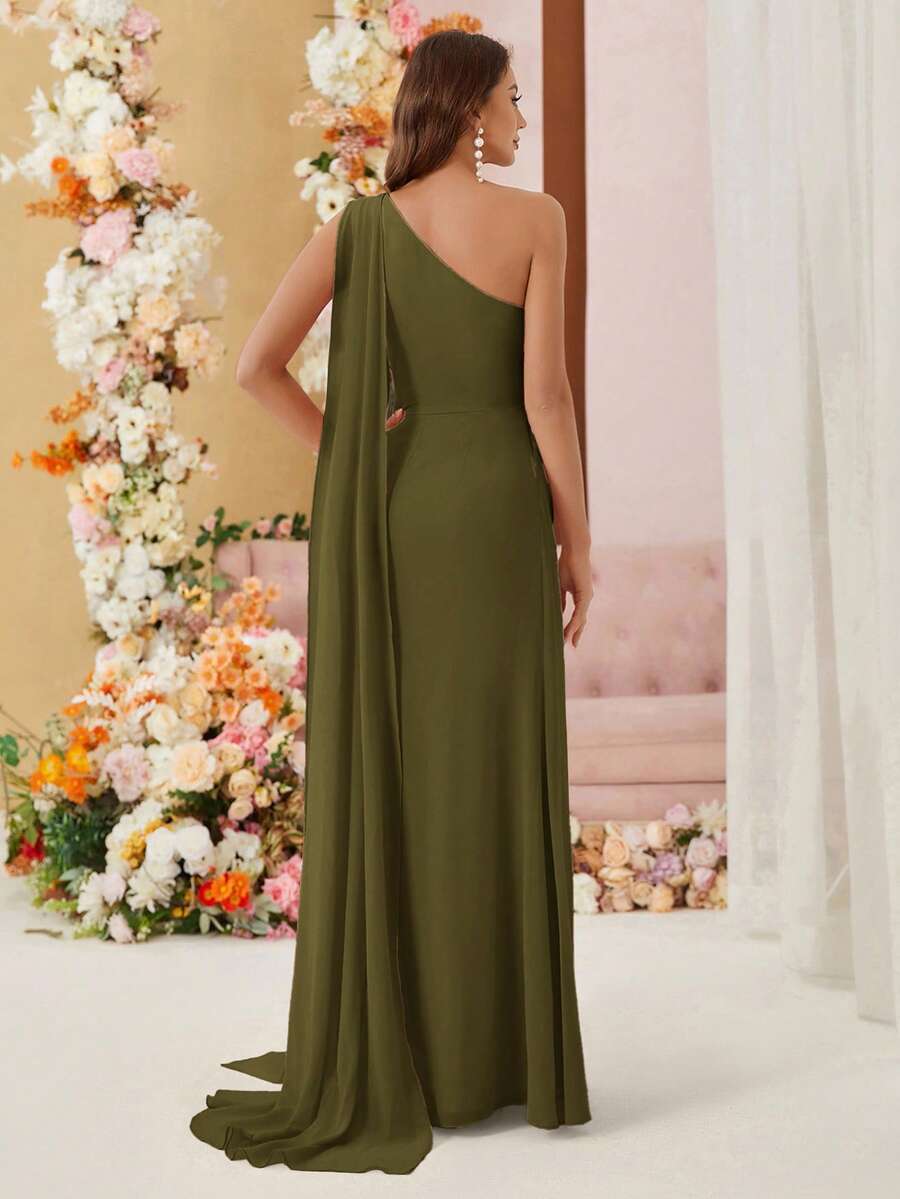 Mujer modelando un jumpsuit elegante verde militar de un hombro con capa larga y detalle fruncido.