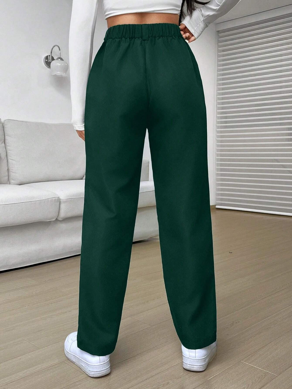 Pantalón casual verde oscuro con cintura natural y corte recortado.
