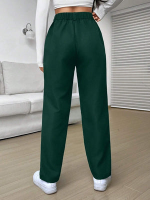 Pantalón verde con detalles de botón y cremallera, visto desde atrás.