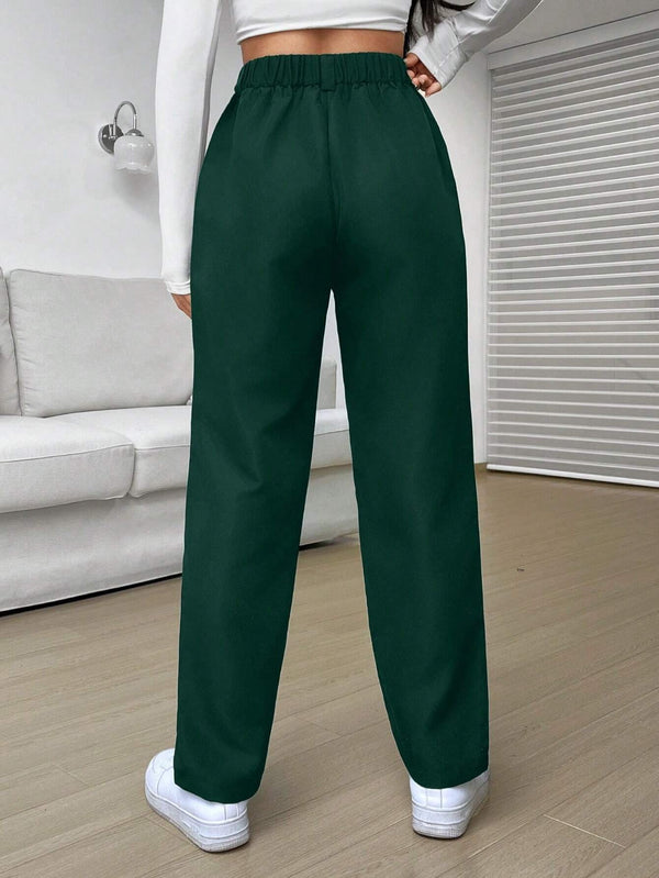 Pantalón verde con detalles de botón y cremallera, visto desde atrás.