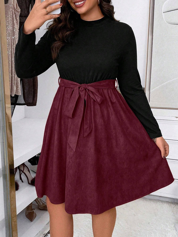Mujer mostrando el cinturón ajustable en su vestido burdeos a línea.