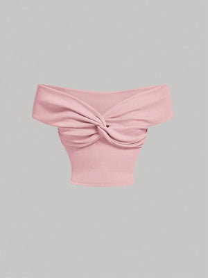 Top rosa crop con nudo frontal y hombros descubiertos – vista frontal
