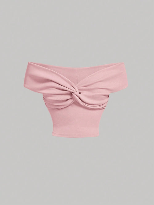 Top rosa crop con nudo frontal y hombros descubiertos – vista frontal