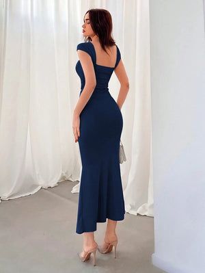 Primer plano del torso de un vestido azul marino ajustado con detalle fruncido en la cintura.