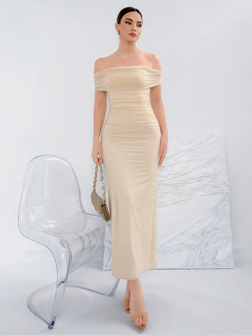 Vestido beige elegante ajustado con hombros descubiertos.