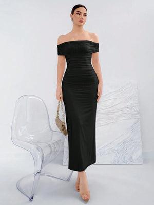 Vista frontal de una mujer usando un vestido negro largo elegante con hombros descubiertos.