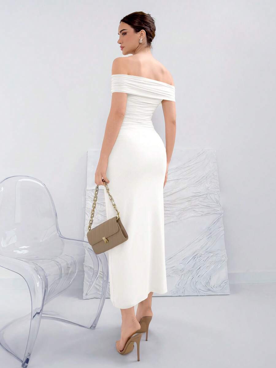 Mujer modelando un vestido blanco largo de hombros descubiertos con detalle fruncido.