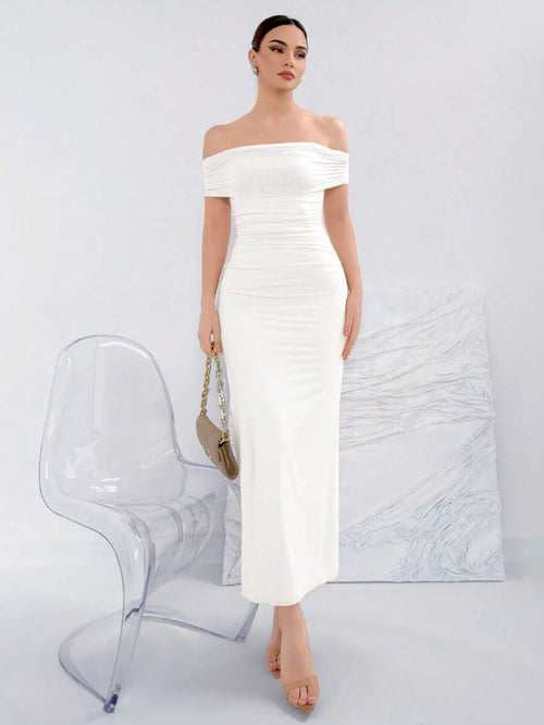Mujer modelando un vestido blanco largo de hombros descubiertos con detalle fruncido.