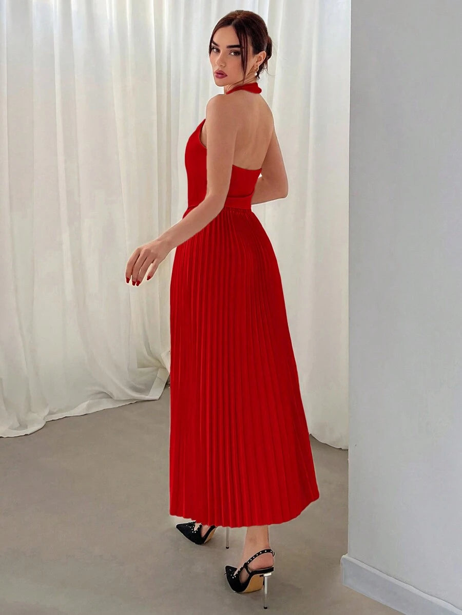 Mujer vistiendo un conjunto rojo elegante de dos piezas con top halter y falda midi plisada.