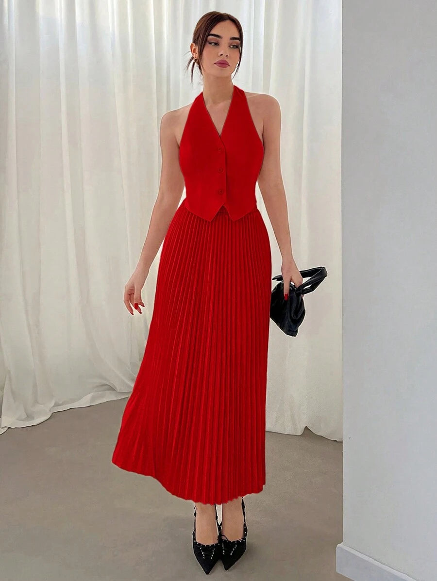 Mujer vistiendo un conjunto rojo elegante de dos piezas con top halter y falda midi plisada.