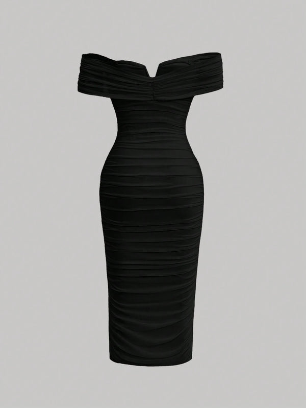 Vista trasera del vestido negro ajustado de hombros descubiertos.
