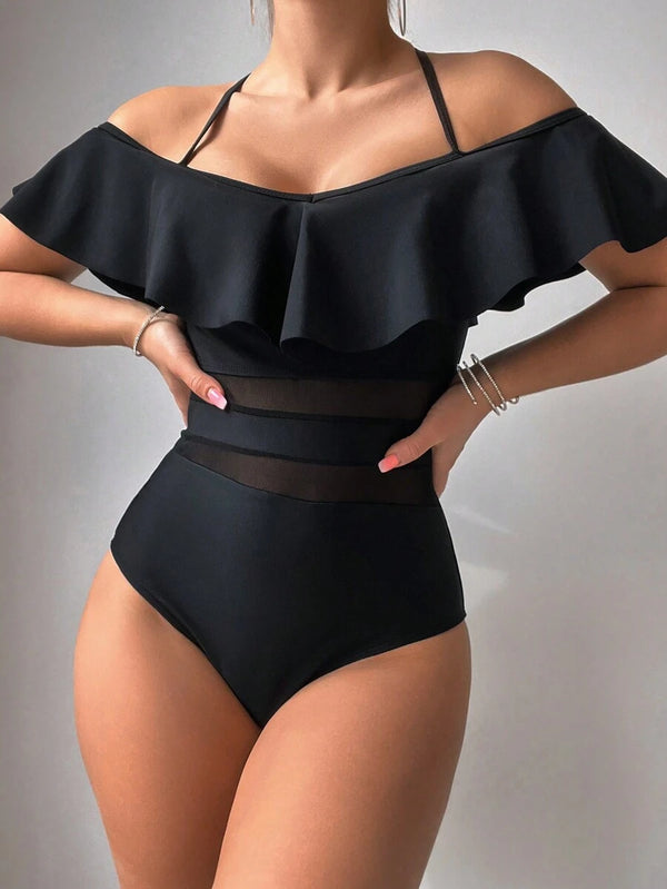 Detalle del diseño de un traje de baño negro con transparencias estratégicas en la zona del abdomen.