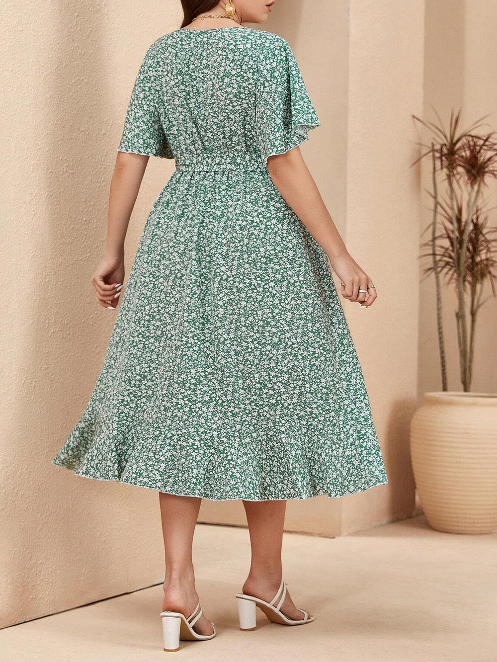 Vista del vestido verde floral con cinturón y bajo con volante, ideal para un look bohemio.
