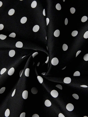Vista lateral del tejido y estampado de lunares de una falda midi negra.