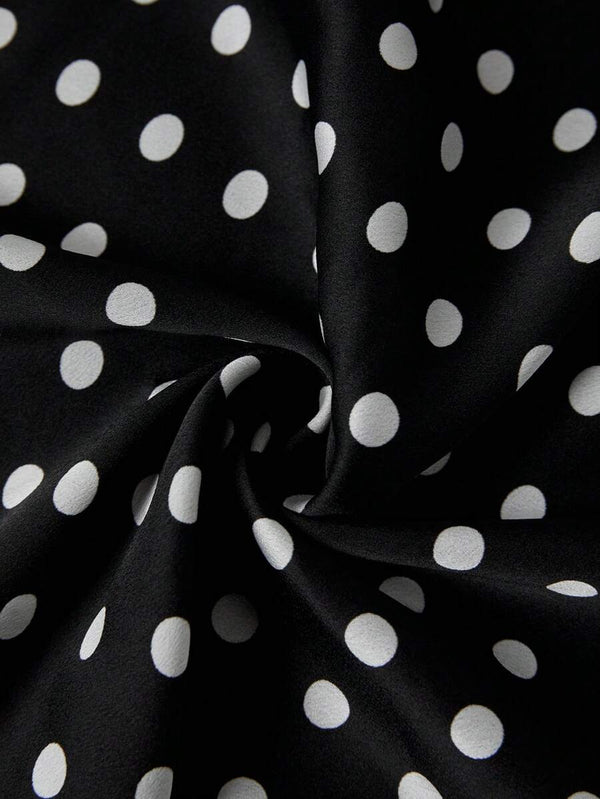 Vista lateral del tejido y estampado de lunares de una falda midi negra.