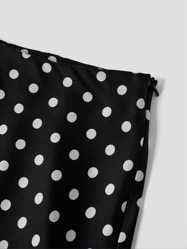 Detalle del bajo y la caída fluida de la falda negra con lunares blancos.
