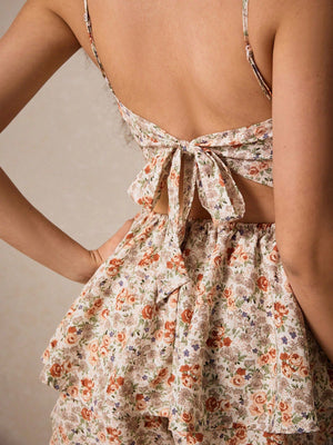 Detalle del nudo y estampado floral del mono corto bohemio albaricoque