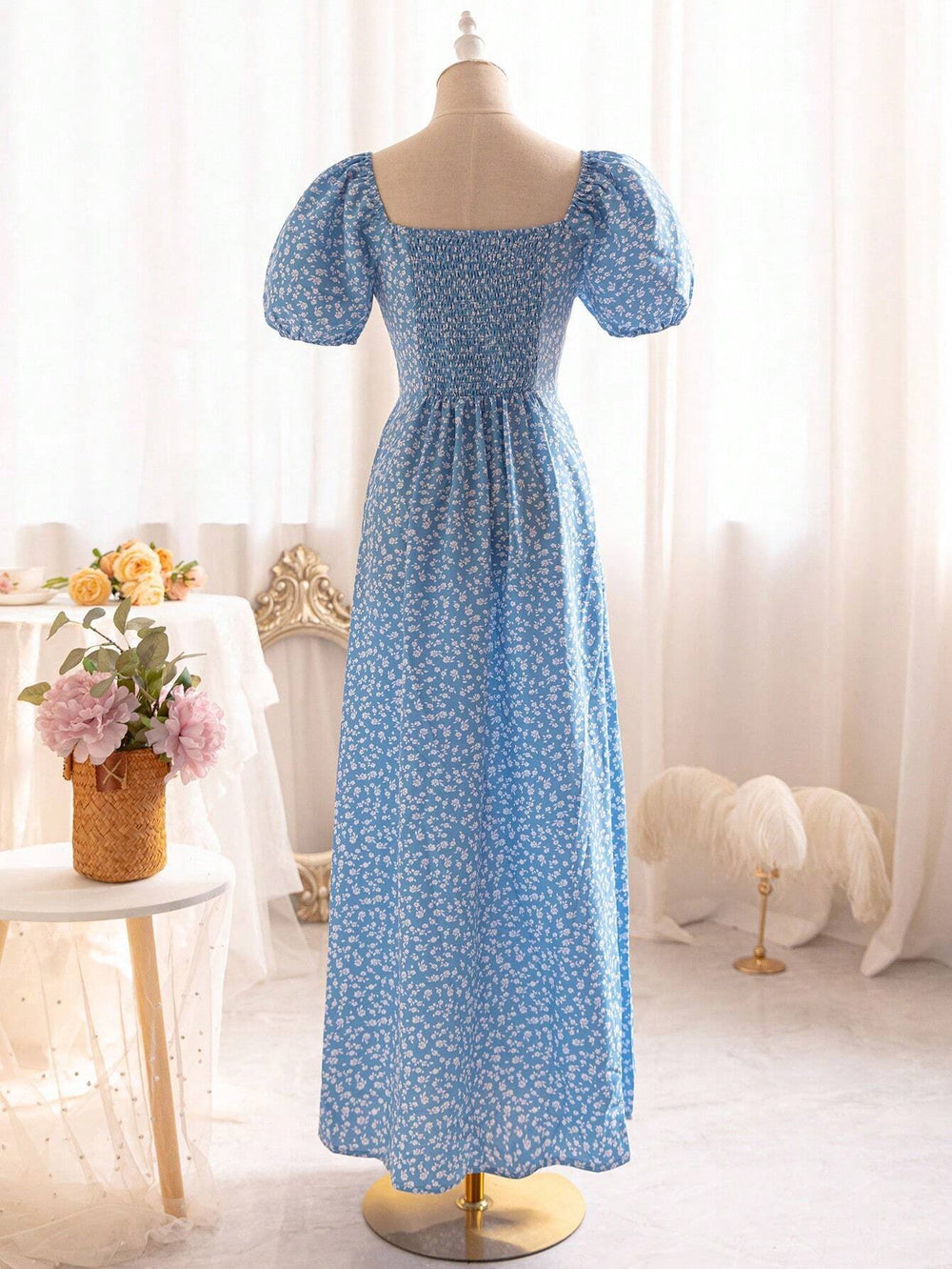 Vista frontal del vestido midi azul con estampado floral y manga farol.
