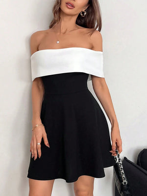 Vestido blanco y negro elegante con hombros descubiertos detalle frontal.