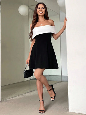 Vestido blanco y negro elegante con hombros descubiertos en look completo.