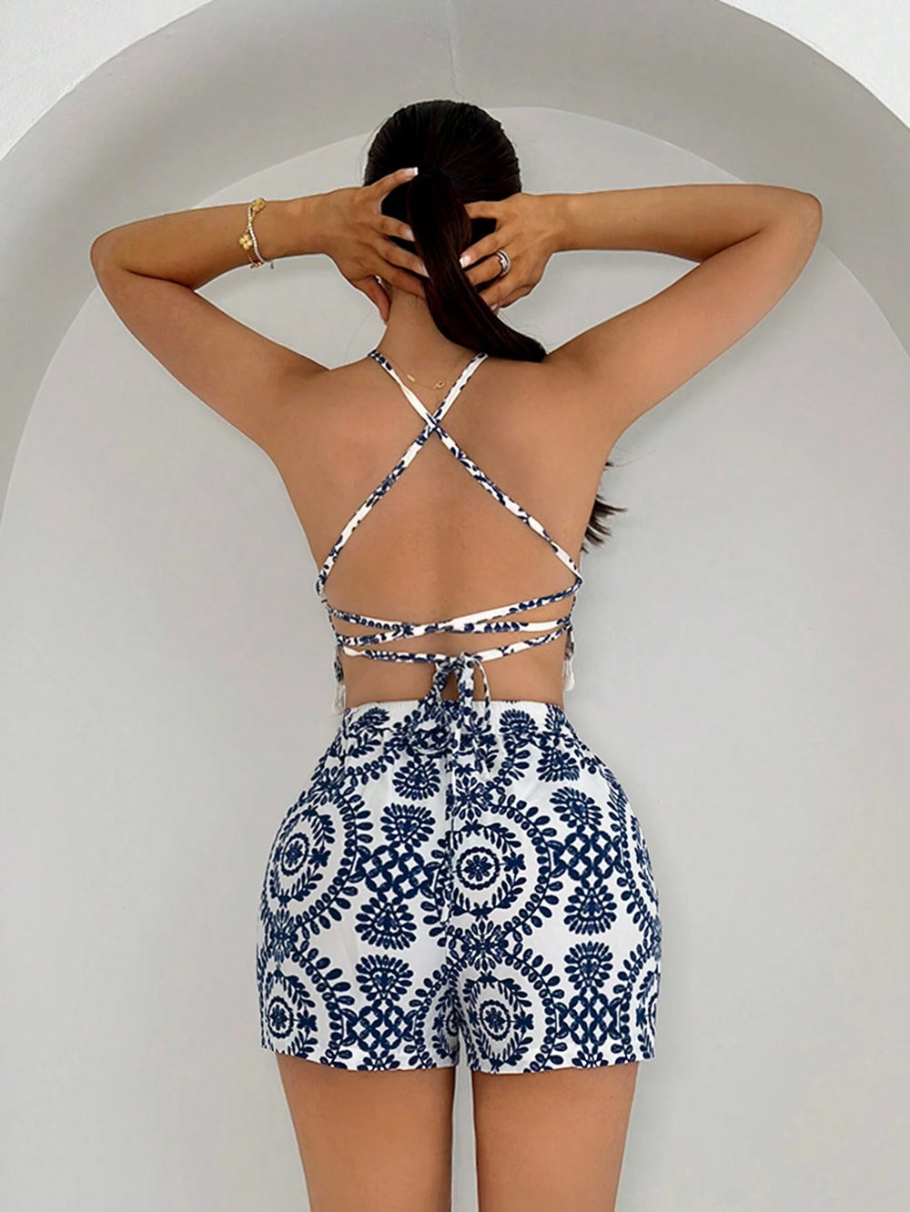 Mujer posando con set bohemio de dos piezas con top halter y short azul con blanco.