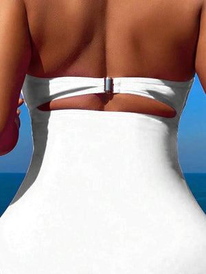 Perfil de un traje de baño entero blanco mostrando el detalle fruncido en la cintura y el corte de la pierna.