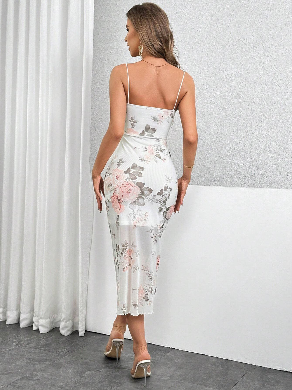 Mujer luciendo un vestido floral midi con tirantes finos y fruncido.