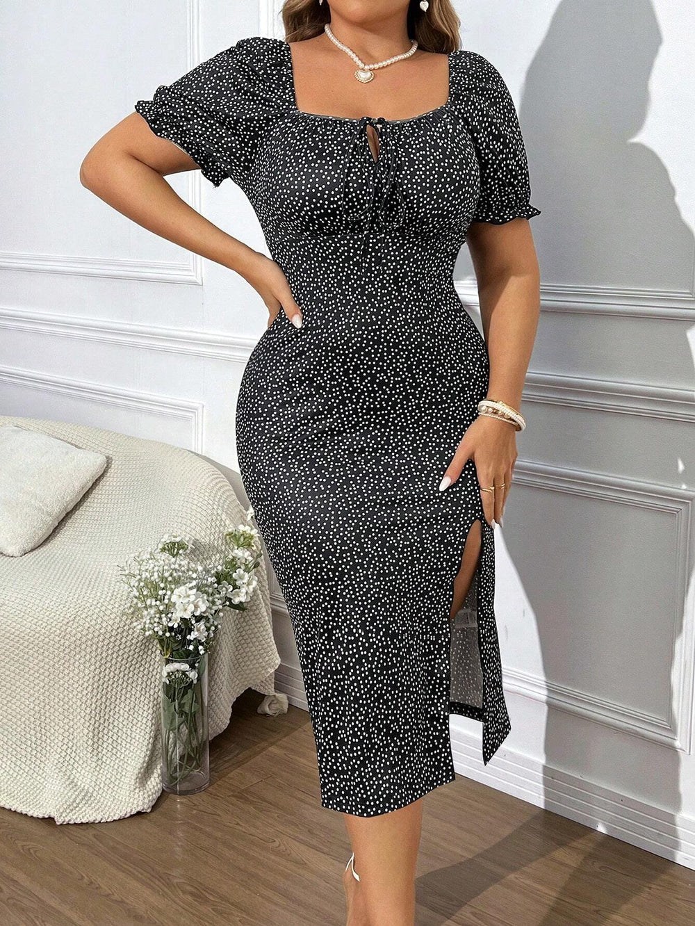 Mujer usando un vestido midi blanco y negro con estampado geométrico y abertura alta.