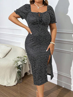 Mujer usando un vestido midi blanco y negro con estampado geométrico y abertura alta.